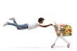 © Ljupco Smokovski - African american guy flying and holding a shopping cart with healthy food
