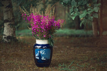 A Large Vase With Flowers Of Ivan Tea On The Ground By A Tree.A Huge Bouquet Of Wild Wildflowers In A Vase.