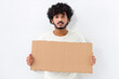 © kucherav - Serious Asian young man activist holds piece of empty cardboard sign in his hands standing on white background