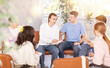 © JackF - Cheerful young student discussing learning assignment with friendly coursemates gathered in classroom