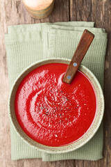 Wall Mural - Fresh homemade tomato soup in bowl with spoon, with freshly ground black pepper on top, photographed overhead on wood (Selective Focus, Focus on the soup).