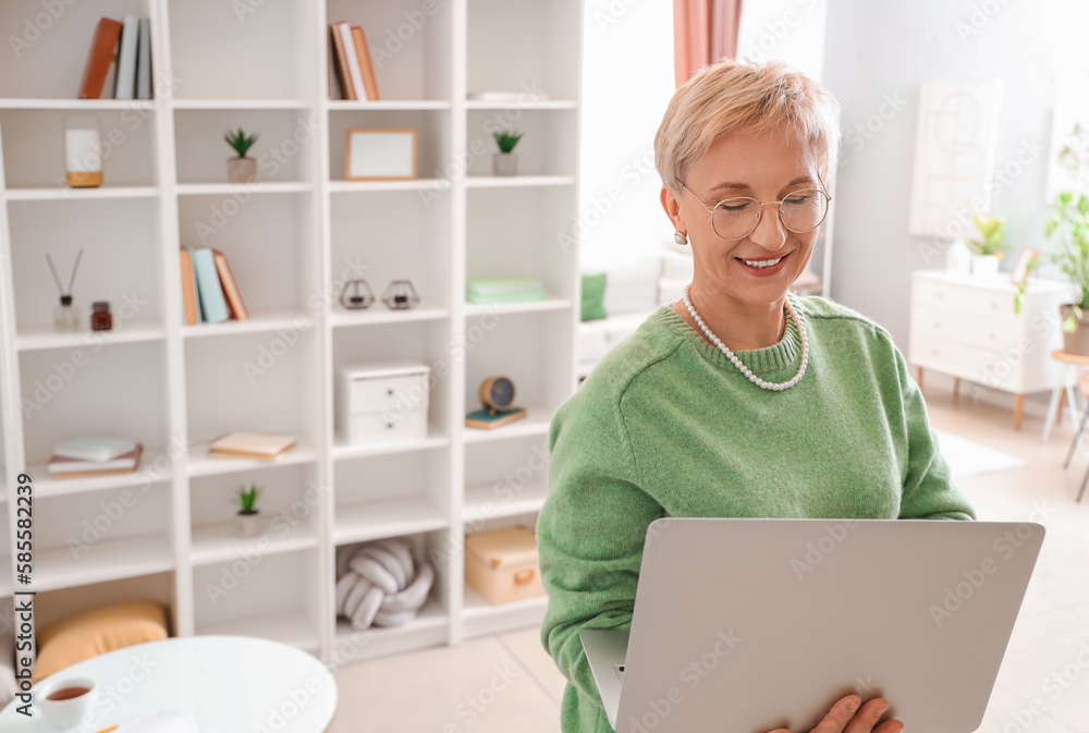 Mature woman with laptop at home