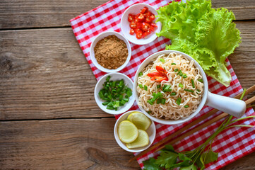 Wall Mural - noodles bowl with vegetable spring onion lemon lime lettuce celery and chili on table food , instant noodles cooking tasty eating with bowl - noodle soup