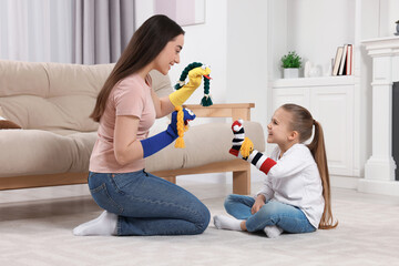 Poster - Happy mother and daughter playing with funny sock puppets together at home