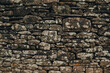 © Strikernia - Rustic stone wall showcasing ancient craftsmanship in Wales amidst vibrant lichen and moss textures