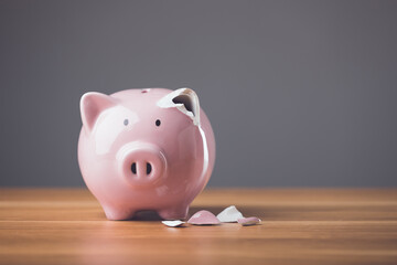 Wall Mural - Financial problem fixing, repair or maintenance idea. Pink broken piggy bank on wooden desk with dark background. Financial, Bankrupt or fail in business concept.