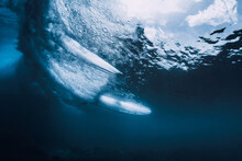 Wave Underwater And Surfer Riding On Surfboard In Ocean. Underwater Crashing Wave And Surfboard In Transparent Water