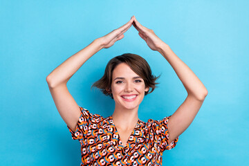 Sticker - Photo of cute cheerful woman wear print blouse smiling showing arms roof isolated blue color background