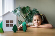 © Westend61 - Girl playing with tree models on table at home