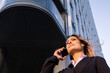 © Westend61 - Businesswoman talking on smart phone near building