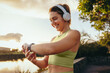 © Jacob Lund - Sports woman choosing a fitness playlist using a smartwatch outdoors