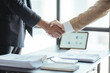 © Kritdanai - Business people shaking hands at meeting or negotiation, close-up. Group of unknown businessmen and women in modern office. Teamwork, partnership and handshake concept, toned