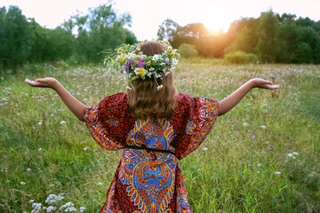 Wall Mural - girl in flower wreath on green meadow, abstract natural background. Floral crown, symbol of summer solstice. Midsummer, wiccan Litha sabbat. pagan slavic holiday Ivan Kupala. wellbeing prayer