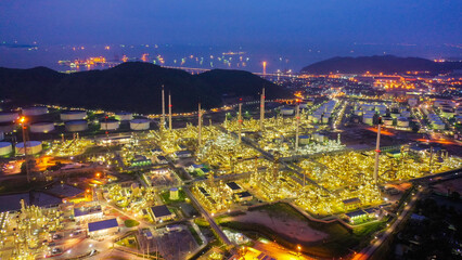 Aerial view of twilight petrochemical oil refinery plants, oil and gas petrochemical industrial, Refinery factory oil storage tank and pipeline steel at night,Ecosystem and healthy environment concept