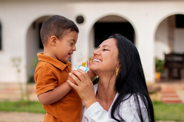 Loving mother affectionately holds her son with Down Syndrome who looks at her with love