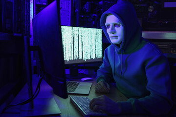 Canvas Print - Hacker in mask working with computers in dark room. Cyber attack