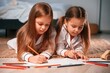 © standret - Drawing and lying down on the floor. Two little girls are playing and having fun together in domestic room