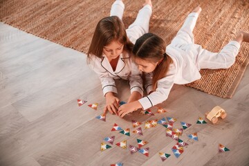 playing card game. two little girls are together in domestic room