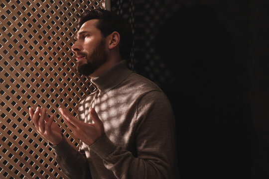 Wall Mural - Man talking to priest during confession in booth, space for text