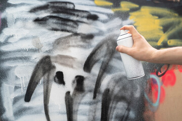 Wall Mural - hand holding spray paint can, artist doing graffiti art on the wall