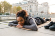 © Drobot Dean - Smiling african girl doing yoga stretching exercises outdoors