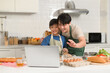 © tonefotografia - Happy smiling Young Asian father and son making video call to mother. enjoy cooking in kitchen at home