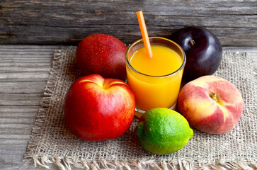 Wall Mural - Fresh ripe fruits and a glass of juice.Multi fruit juice.Juice mix fruit on wooden table.Healthy drink or diet concept.Selective focus.