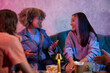 © DragonImages - Positive young women chatting at party