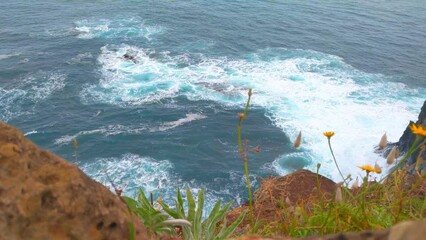 Wall Mural - Waves of turquoise water crash against the rocks