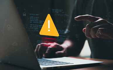 People hand using smartphone and computer laptop that show warning sign after got attack by malware from hacker that commit cyber crime or software crash to cause an error, network malfunction.