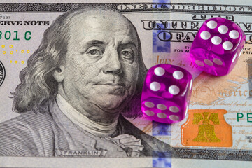 two purple dices on US 100 dollar banknotes background