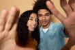 Latin american boy and girl having fun standing together doing selfie together gesticulating with hands in front of camera, sharing love vibes with each other. Romantic relationships