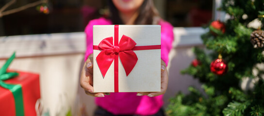 Wall Mural - Happy excited asian woman hands holding Christmas gift box. cheerful girl packing Xmas present or open box xmas new year birthday gift.