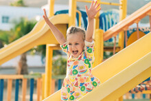 Child Playing On Outdoor Wooden Playground. Kids Play On School Or Kindergarten Yard. Active Kid On Colorful Slide. Healthy Summer Activity For Children