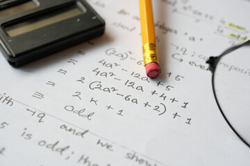 hand writing algebra equations on a paper