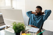 © Prostock-studio - Happy black businessman taking break and enjoying result of project, sitting at table, looking at computer screen