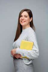 Wall Mural - Adult student or teacher woman holding yellow book. Isolated portrait.