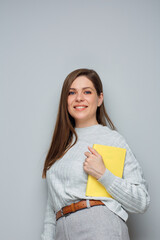 Wall Mural - Smiling woman holding yellow book. Isolated portrait.