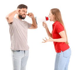 Wall Mural - Young woman with megaphone shouting at her husband on white background