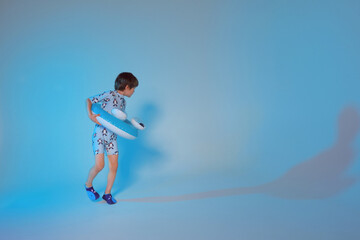 Happy cute boy 6 years old with a life buoy at the blue background