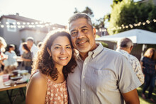 Portrait Of Mature Hispanic Couple At Family Gathering Outdoors In Backyard In Summer.