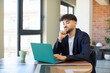 © kues1 - young handsome man smiling with a happy, confident expression with hand on chin. freelance concept with laptop