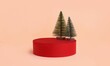 Christmas setup with small Christmass trees on red podium for product display against peach wall