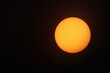 © kanin - Orange sun on a black background. Big yellow-orange sun with sunspots photographed through a telescope filter on a black background with copy space. selective focus