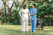 © NanSan - Young asian care helper with asia elderly woman on wheelchair relax together park outdoors to help and encourage and rest your mind with green nature. Help support yourself to learn to walk. walker