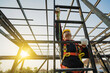© Phoophinyo - Asian construction worker wearing safety body working at height factory roof steel structure