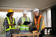 © Nuttapong punna - Contractor and architect looking at plan, tablet, laptop and talking about working on big project. Building in construction process interior. team work .