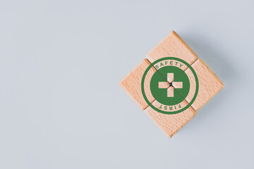 Safety  first signs, work safety, caution work hazards, danger surveillance, zero accident concept Green  safety first symbol on wooden cubes block with  background and copy space