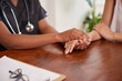 © Meeko Media - Close up of doctor holding patients hands, comfort during medical consult