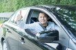 © Patcharanan - Happy male driver smiling while sitting in a car show thumbs up. Young asian man smile and looking through window. View of a Young man driving his car to travel on his holiday vacation time.